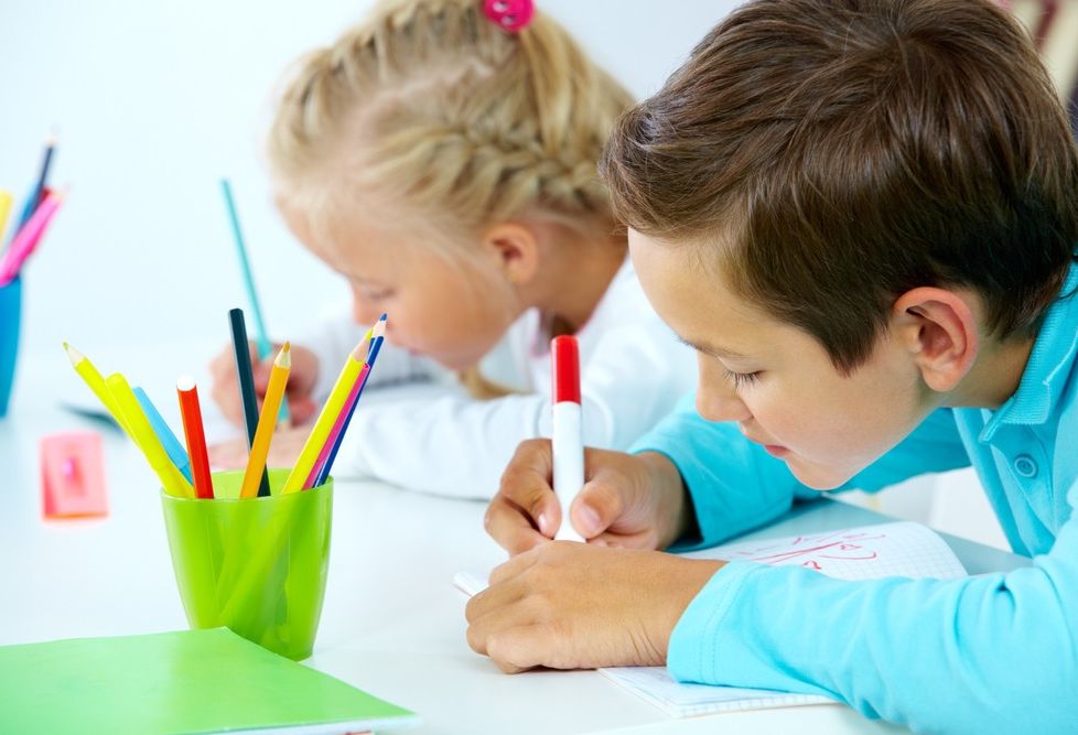 niños concentrados dibujan